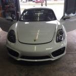 Porsche in repair shop with doors open