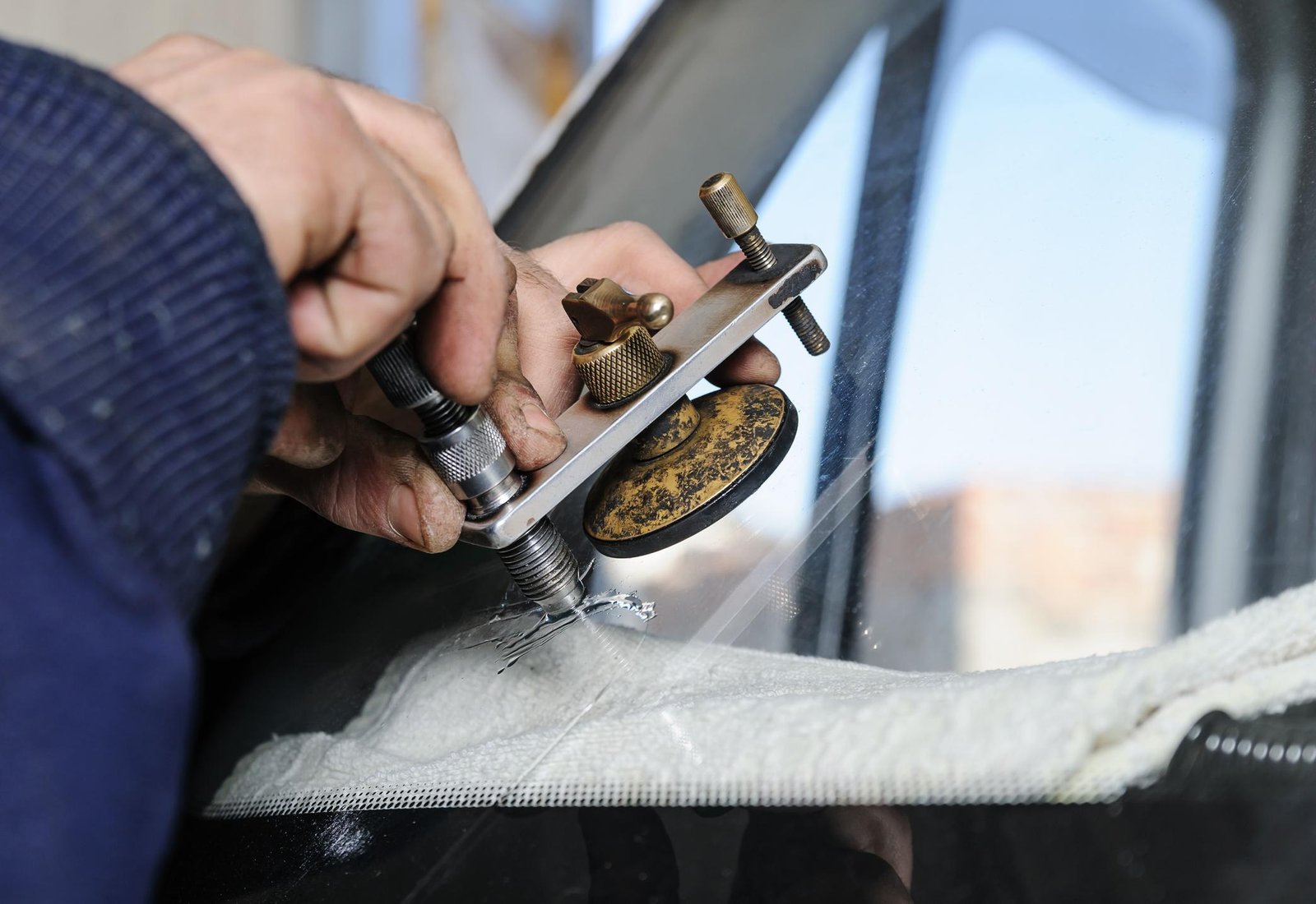 Repair cracked windshield. Fitter is using Windshield Repair Crack Bridge.