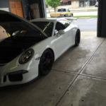 White Porsche with the hood open